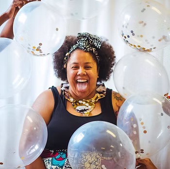 Sheba Gittens with balloons around their face.