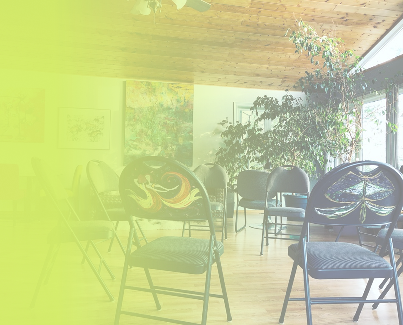 Circle of folding chairs in a living room with vaulted a ceiling and windows.
