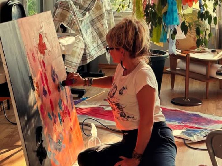 Person sitting on the floor painting.