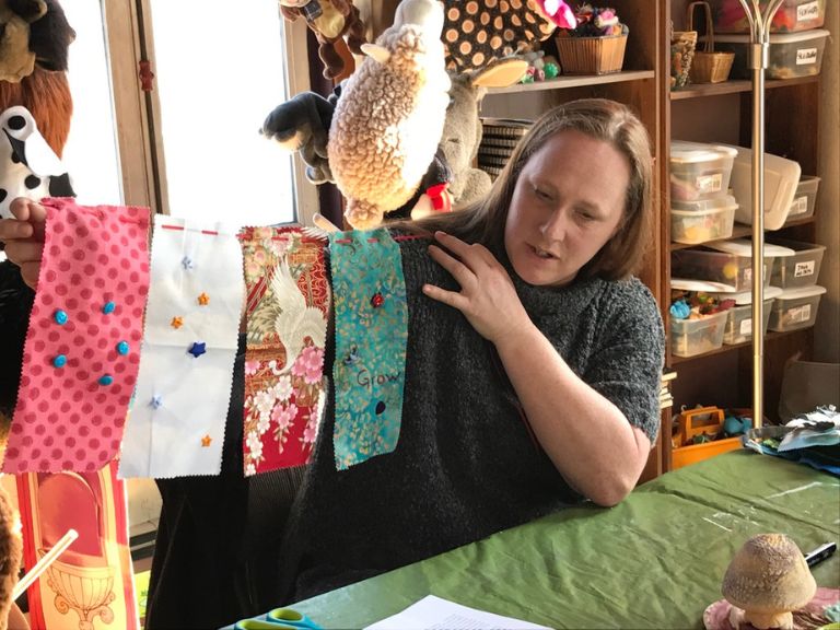 Person holding up art project with different fabrics.