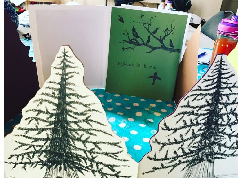 Two tree art pieces with card behind them.