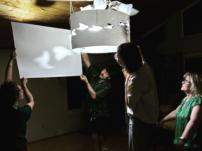 Group of four people working on lighting art project.