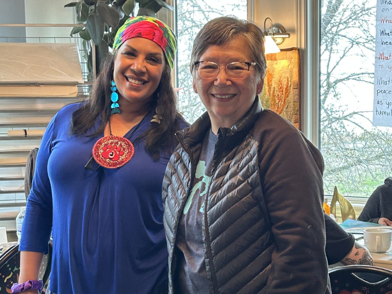 Two people standing together in workspace.