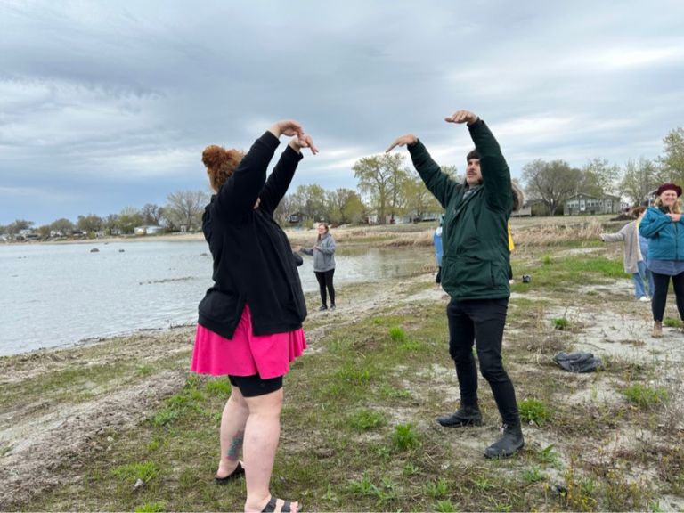 Group of people along shoreline of a lake.