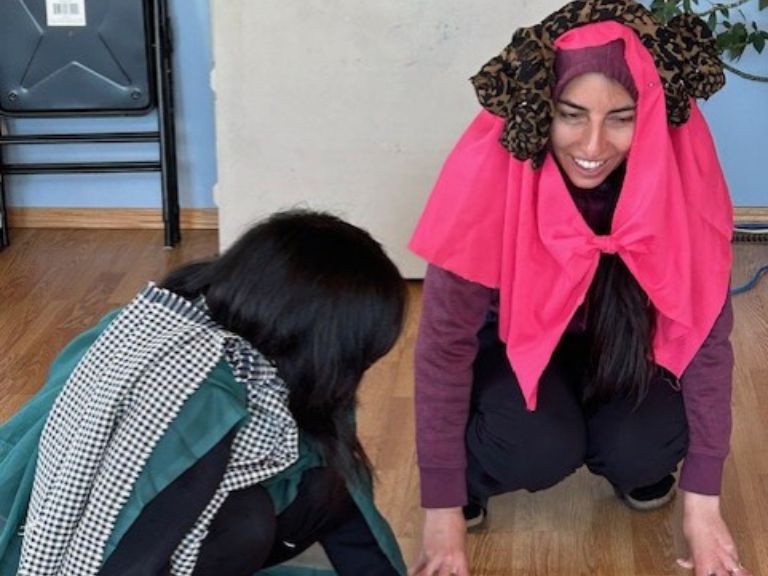 People on floor playing a game with different materials.