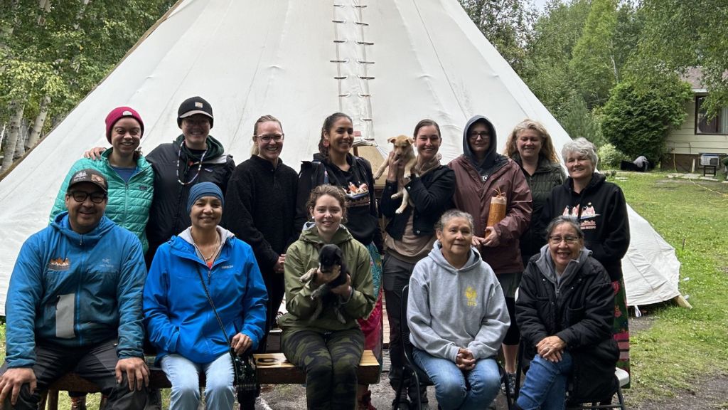 Group of people in front of tipi.