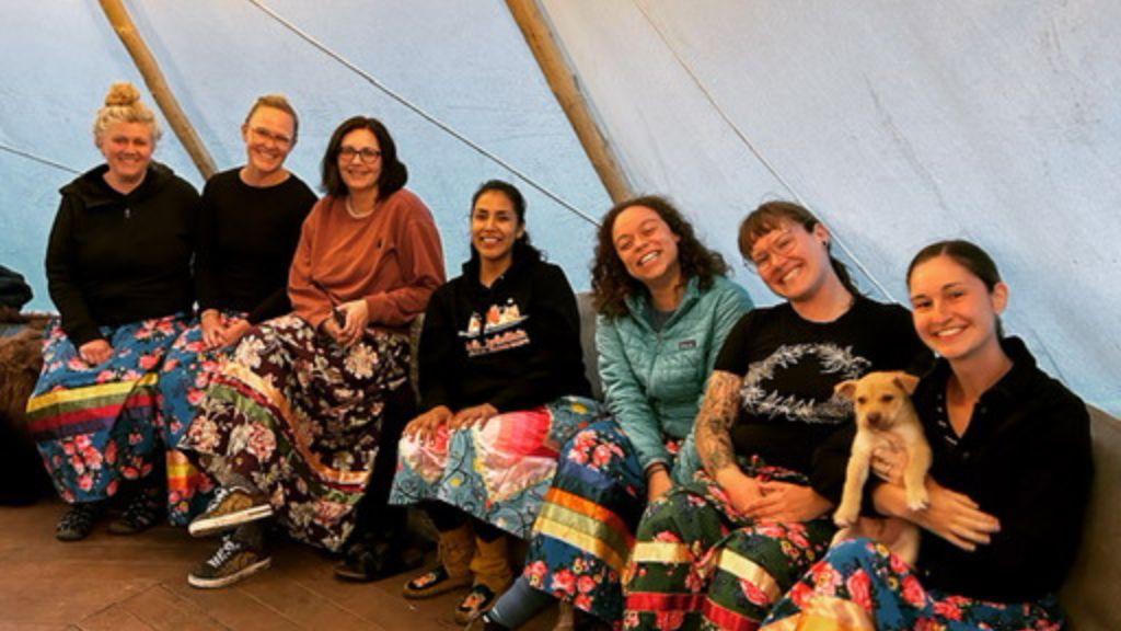 Group of people sitting in a tipi.