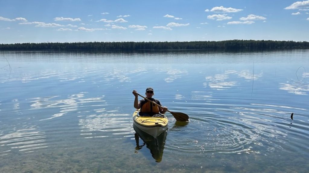 Person in a kayak on a lake.