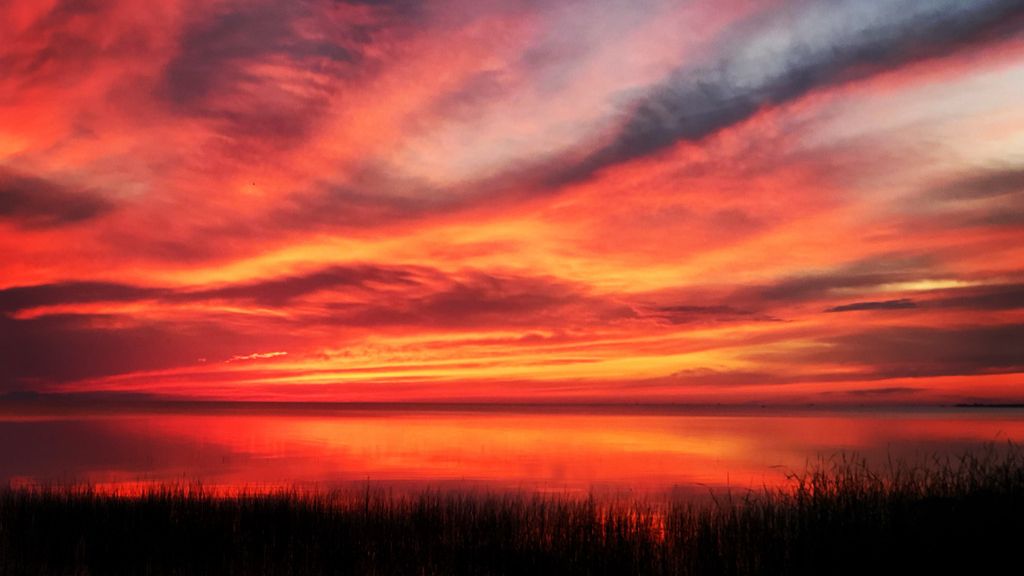 Sun setting over lake.