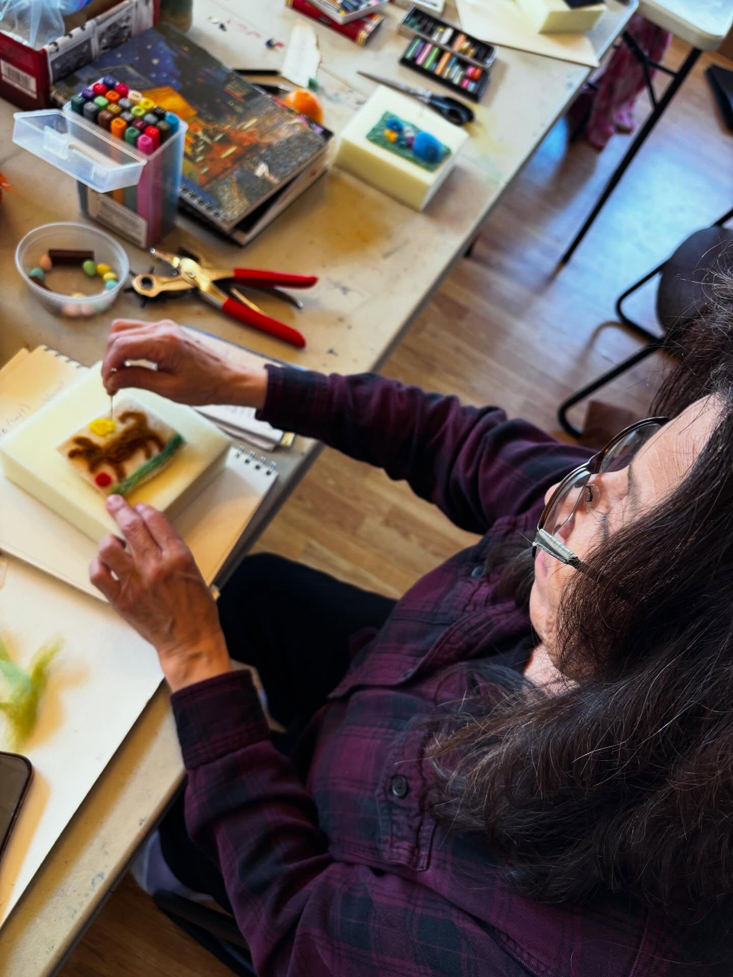 Student felting at a table at Painted Sky Studio