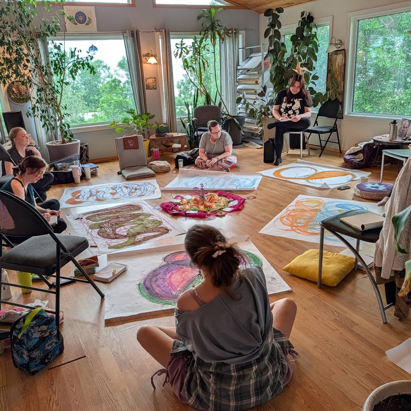 Students sitting on floor of Painted Sky Studio space with artwork between them