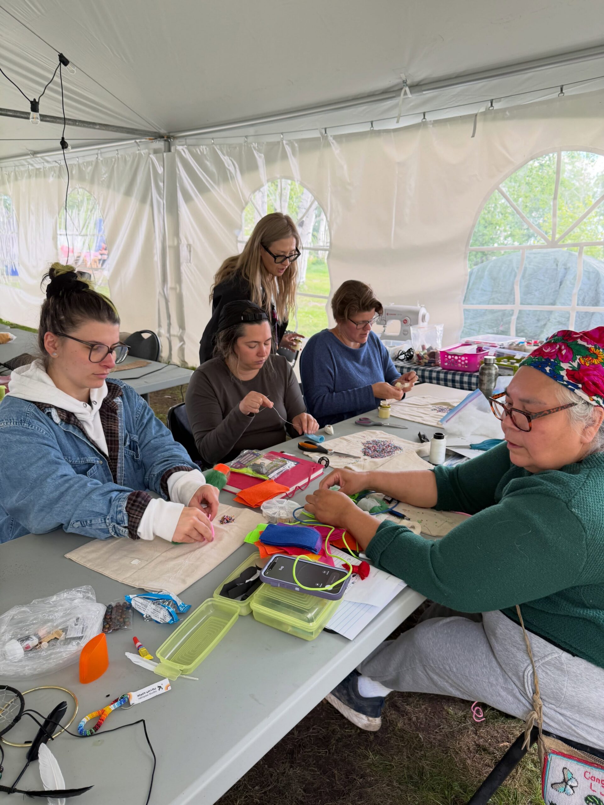 Students sitting at a table art - making at kâniyâsihk Culture Camp